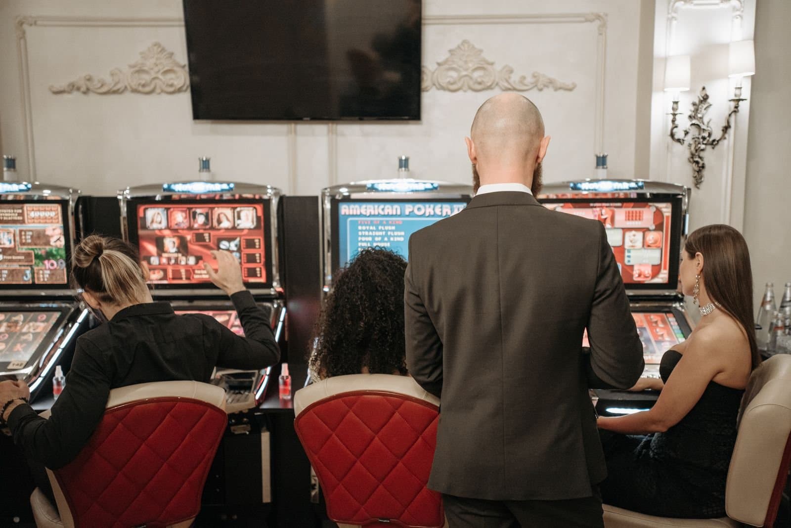 People playing a row of slot machines in a casino