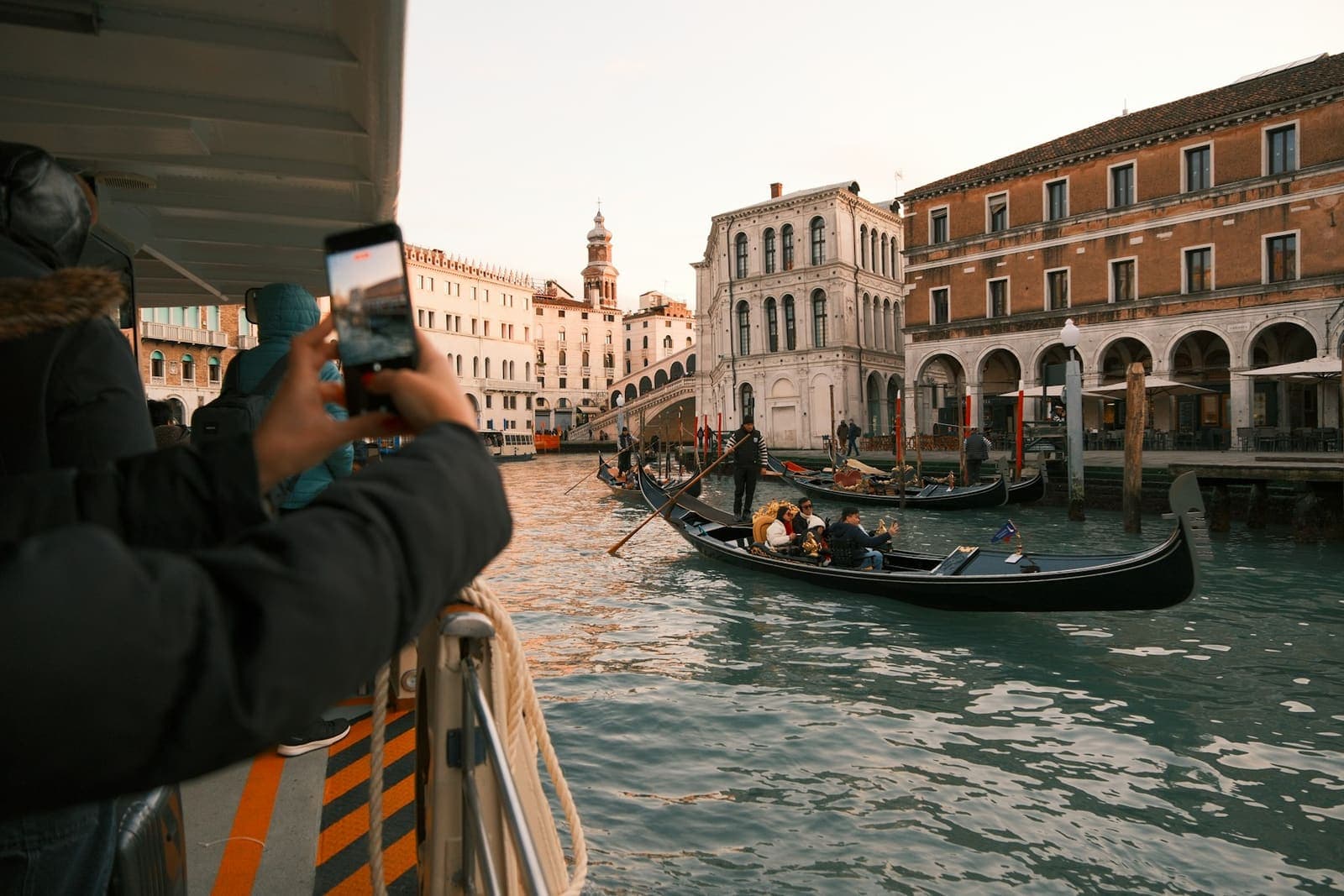 Gondolas on a wide canal lined with Venetian palaces.