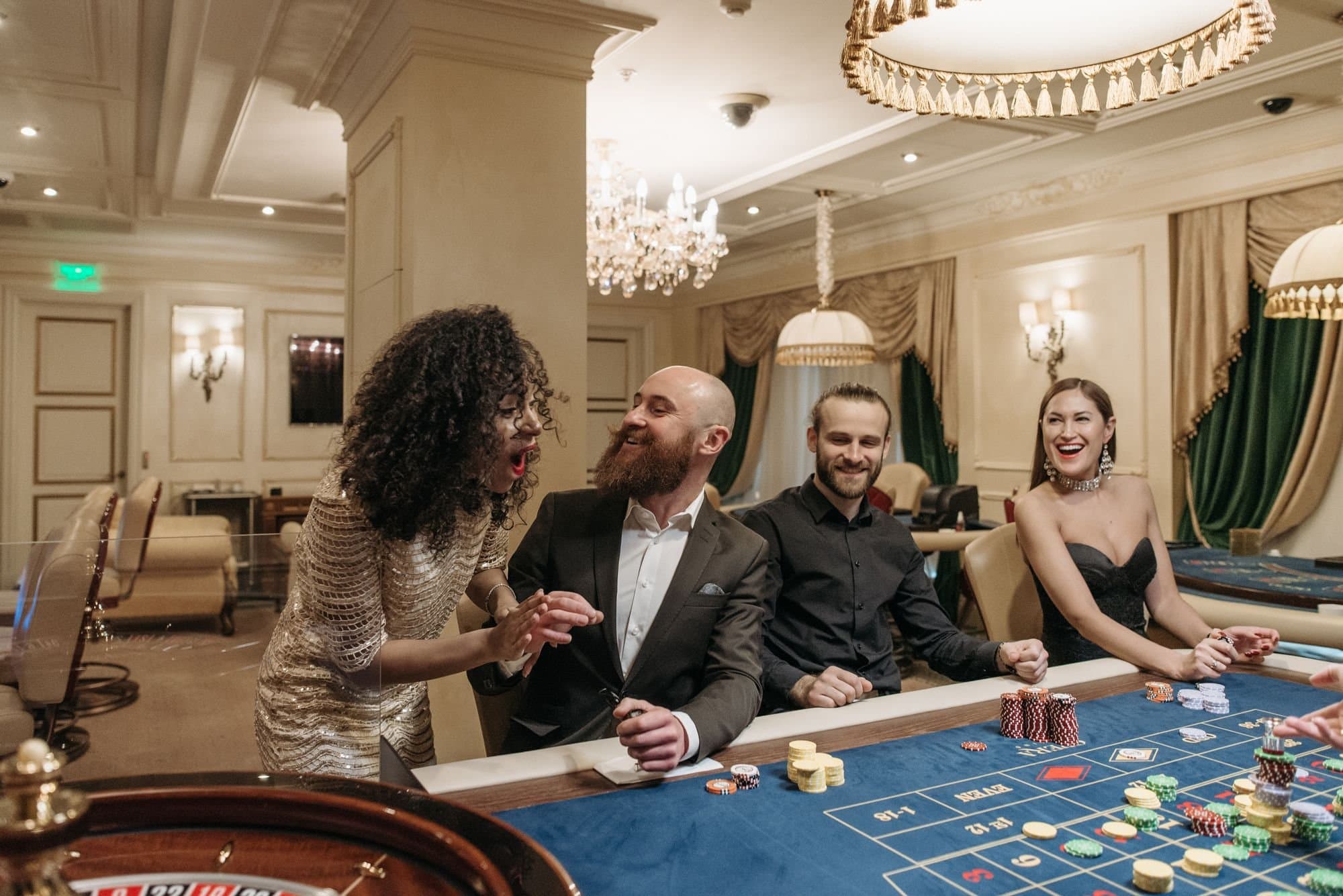 Friends laughing and talking together at a casino table.